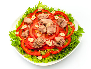Tuna salad with lettuce, bell pepper, garlic and tomatoes isolated on white background. Tasty food.