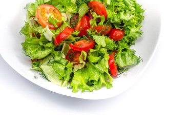 White bowl of fresh vegetables - dill, tomatoes and green salad leaves. White background, isolated.
