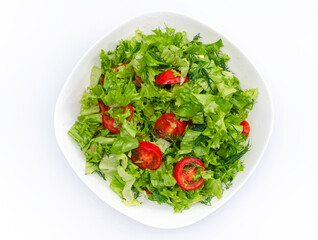 White bowl of chopped vegetables - dill, tomatoes and lettuce. White background, isolated.