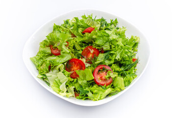 White bowl of chopped vegetables - dill, tomatoes and lettuce. White background, isolated.