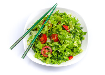 White plate of salad with vegetables isolated on white background. Wooden chopsticks for food.