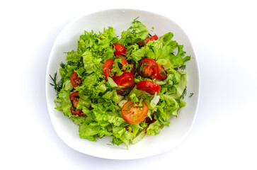 White bowl of chopped vegetables - dill, tomatoes and lettuce. White background, isolated.
