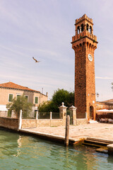 Old bell tower brick with clock in Burano venice italy 