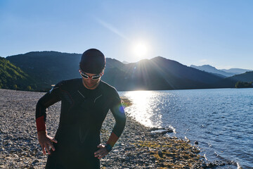 Authentic triathlon athlete getting ready for swimming training on lake
