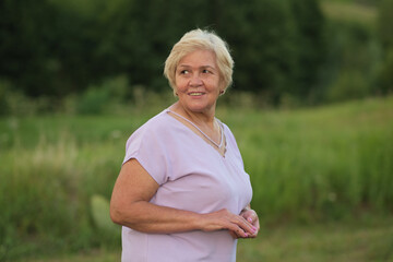 Fototapeta na wymiar Senior woman smiles in a natural setting, radiating joy. Perfect for content on aging positively and embracing life s later years.
