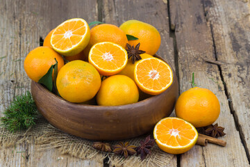 fresh tangerines in a bowl on wooden background