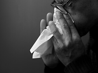 blowing nose after catching the cold and flu with grey background with people stock image stock...