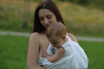 Fototapeta premium A child's glee while being hoisted by mom outdoors. Reflects the bond and the universal language of happiness
