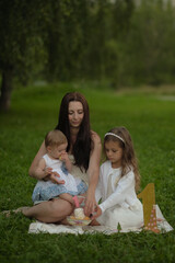 Naklejka premium The candid joy in a mother's eyes as she interacts with her children in the great outdoors, underscores the importance of family time and the instinctual bond of motherhood.