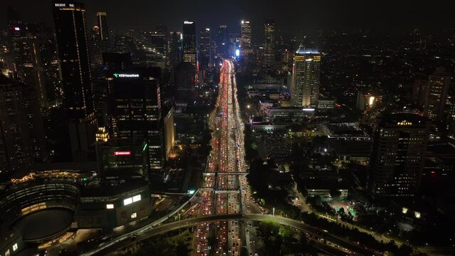 night illuminated jakarta city downtown high traffic street road interchange aerial panorama 4k indonesia
