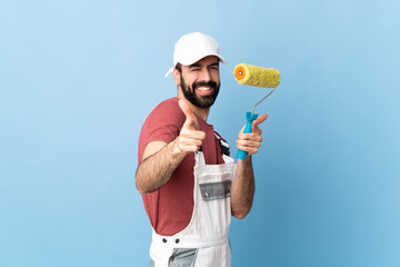 Adult painter man over isolated blue background pointing to the front and smiling - obrazy, fototapety, plakaty
