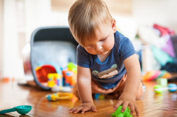 Cute baby boy playing with his colorful toys in the living room. Education toys, child development