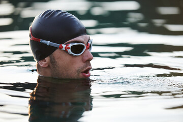A triathlete finds serene rejuvenation in a lake, basking in the tranquility of the water after an...