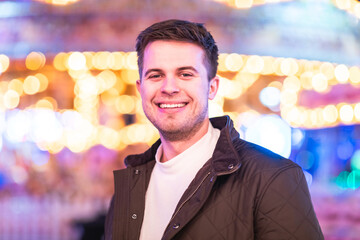 Smiling man portrait at amusement park looking at camera and smiling