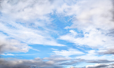 Blue summer sky covered with white and dark clouds. Heavenly wallpaper. Cloudscape. Sky background with copy space. Design element