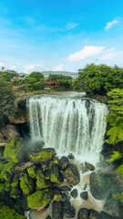 Fototapeta premium Aerial view of Thac Voi - Elephant waterfall, forest and city scene near Dalat city and Linh An pagoda in Vietnam