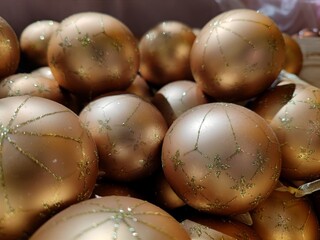 Golden colored Christmas baubles in baskets on store shelves ready to be sold to visitors during a Christmas show during Christmas season