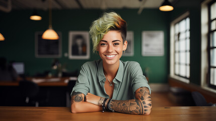 young happy girl with colored hair and tattoos looking at the camera in a working place