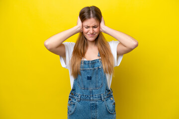 Young caucasian woman isolated on yellow background frustrated and covering ears