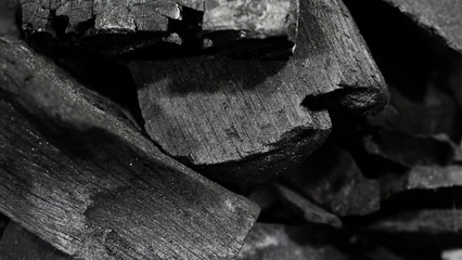 Fensteraufkleber Black Charcoal on black textured floor. © Teo