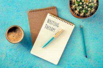 Writing Therapy. Notebook with a pen, coffee, and a plant, overhead flat lay shot on a teal...