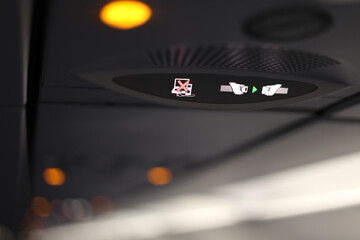 Aviation safety rules. Close up photo with safety light signs inside and airplane like no usage of...