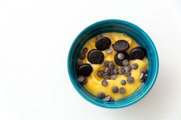 a birds eye view of a mango acai bowl topped with chocolate chips and cookies.