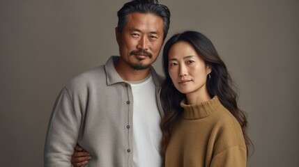 Fototapeta premium At home, an Asian couple in their middle age wraps themselves in a loving embrace, radiating happiness.