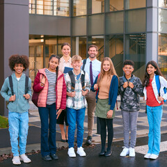 Portrait Of Class Of Secondary Or High School Pupils Standing Outside School Building With Teachers