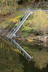 Eine Leiter spiegelt sich im Wasser des Albstausee bei St. Blasien
