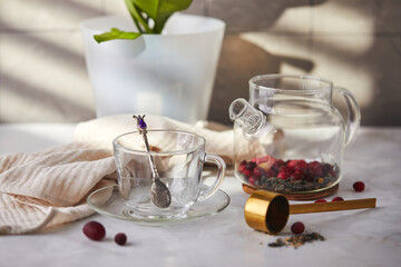 Fruit and berry tea. Preparation. Empty glass teapot and cup on the table