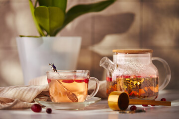 Fruits and berries tea. Glass teapot and cup on the table