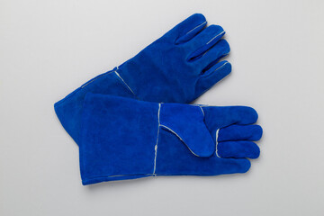 Blue construction gloves on color background, top view