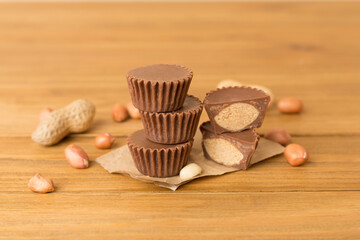 Fototapeta na wymiar Tasty chocolate peanut butter cups on wooden table