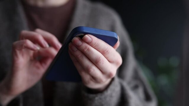 Close-up view on female hands with mobile phone at home, using messanger