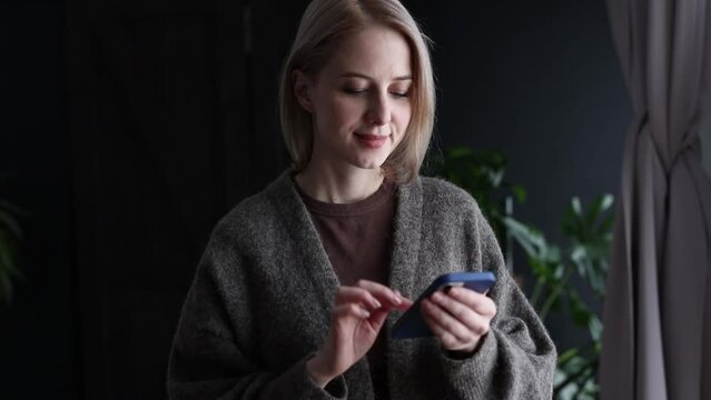 Close-up view on female hands with mobile phone at home, using messanger