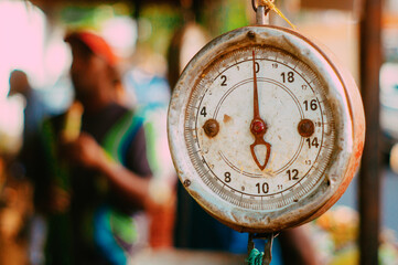 Well worn weight scale with spring dial and scale blade with large screen in a popular urban market in South America