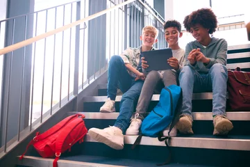 Foto op Canvas Three Male Secondary Or High School Pupils Inside School Building On Stairs With Digital Tablet © Monkey Business