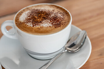 a close up image of a Cappuccino coffee topped with chocolate powder.
