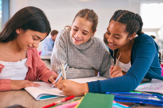 Three Female Secondary Or High School Students Collaborating In Study Area 