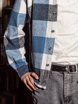 Young man in a blue flannel plaid shirt. Shirt over a white T-shirt