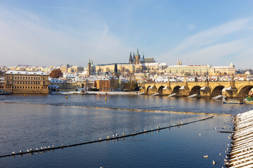 Obraz premium Snowy Prague Lesser Town with Prague Castle and Charles Bridge above River Vltava in the sunny Day , Czech republic