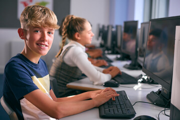 Portrait Of Male Secondary Or High School Student Sitting At Computer Screen In IT Class 