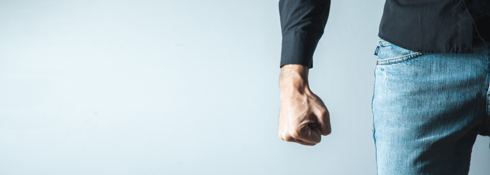 angry man fist on gray wall background