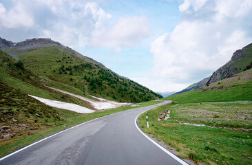 Naklejka premium Asphalt road in Alps mountains. Road trip concept. Beautiful landscape.
