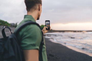 Anonymous man making video of sea and nature over smartphone