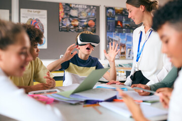 Amazed Male Secondary Or High School Pupil Wearing VR Headset In Science Class With Female Teacher
