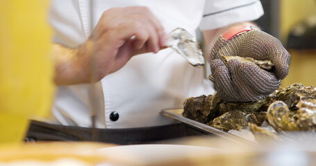 chef preparing oysters dish in elegant restaurant.