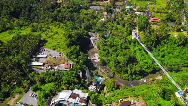 Tegenungan Waterfall surrounded by lush green tropical jungle near Ubud village at Bali Island, Indonesia. Aerial drone footage at daytime