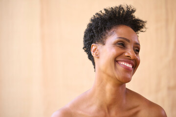 Beauty Portrait Of Smiling Mature Woman With Bare Shoulders Against Natural Background